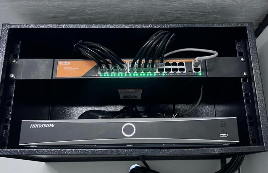 Rack com gravador NVR Hikvision e switch de rede para condomínio